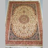A Keshan carpet, with a central medallion and floral designs, on a cream ground,