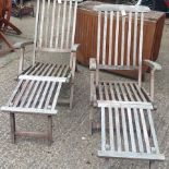 A pair of teak steamer chairs, together with a drop leaf garden table,