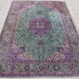 A Horta carpet, with a large central medallion and floral designs, on a green ground,