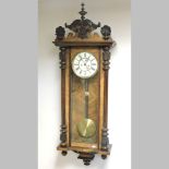 A late 19th century walnut cased Vienna style regulator, with a white enamel dial,
