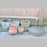 A millstone, 54cm, together with two reconstituted stone garden pots,