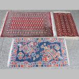 A Bokhara rug, with three rows of central medallions, on a red ground, 210 x 130cm,