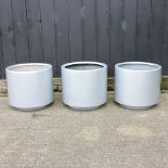 A collection of three silver painted garden pots,