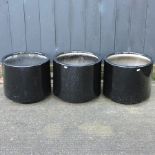 A collection of three circular black painted garden pots,