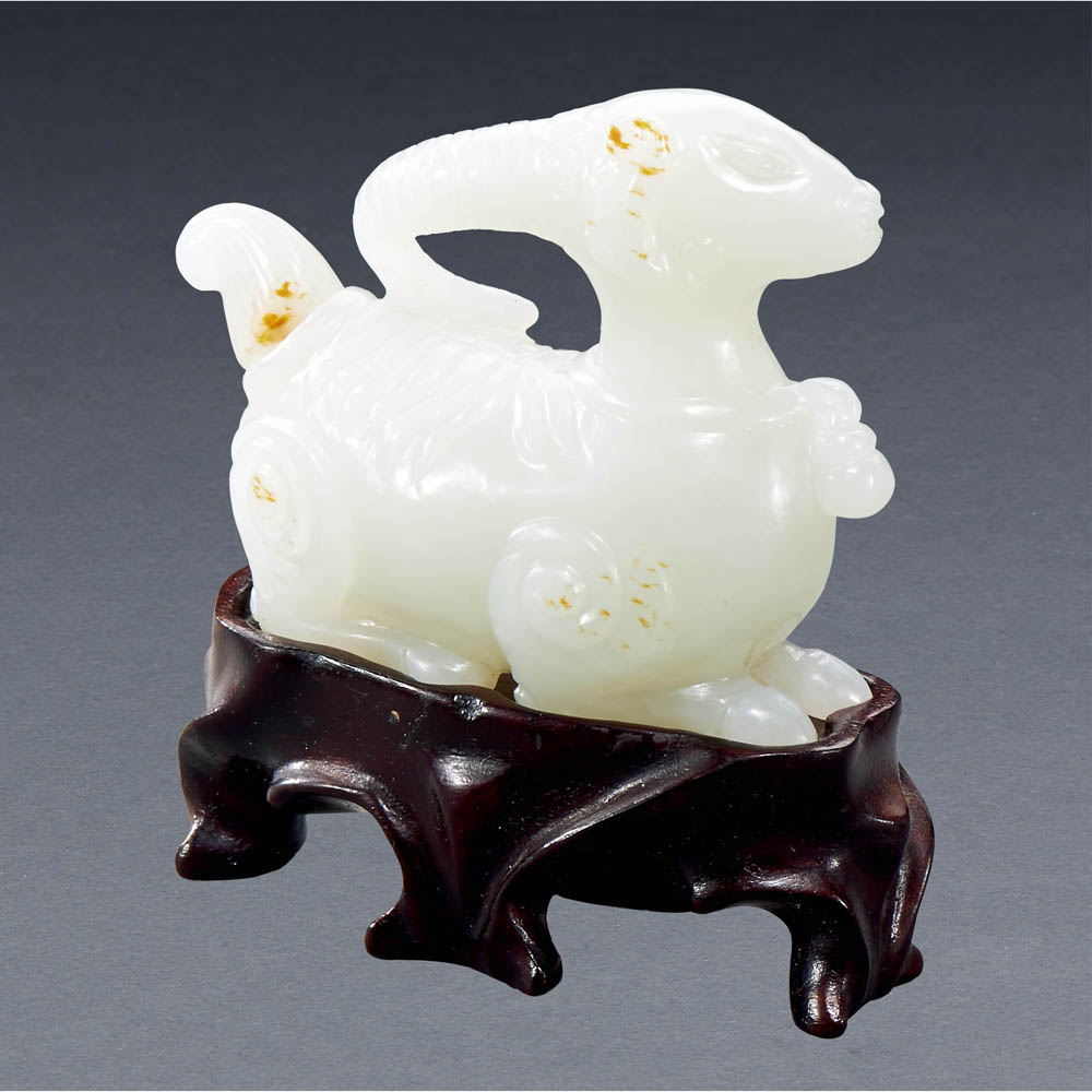 A CHINESE WHITE AND RUSSET JADE HORNED BEAST SNUFF BOTTLE