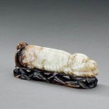 A CHINESE PALE CELADON AND RUSSET JADE RECUMBENT DOG