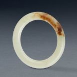 A CHINESE WHITE AND RUSSET JADE BANGLE