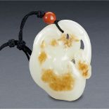 A CHINESE WHITE AND RUSSET JADE LINGZHI PENDANT