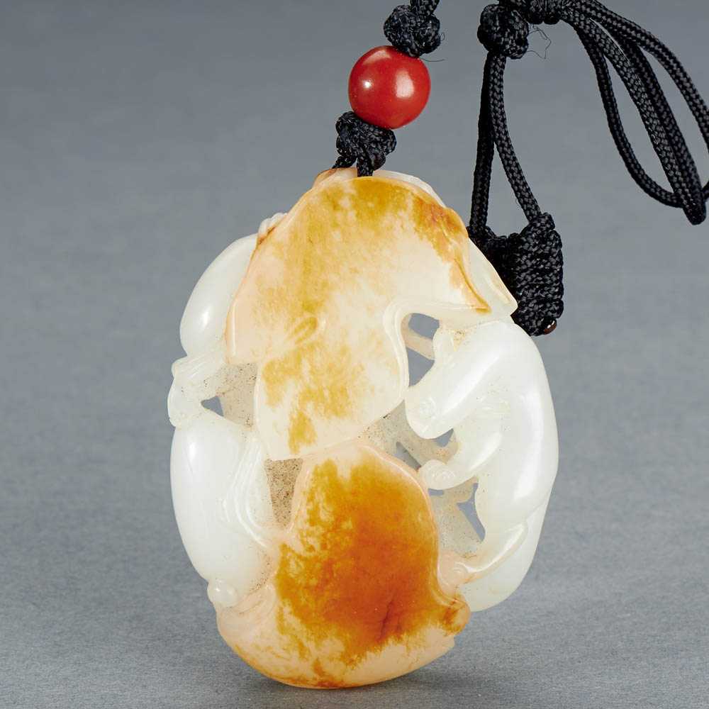 A CHINESE WHITE AND RUSSET JADE 'SQUIRREL AND PUMPKIN' PENDANT
