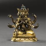 TIBETO-CHINESE, EARLY QING DYNASTY A GILT-BRONZE SEATED FIGURE OF THREE-FACED WITH EIGHT-ARMED