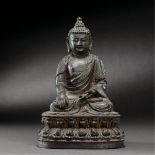 CHINA, MING DYNASTY (1368-1644) A COLD-GILDED BRONZE SEATED FIGURE OF SHAKYAMUNI H 23 cm. (9 in. )