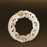 HAN DYNASTY (206 BC-AD 220) AN UNEARTHED WHITE JADE DRAGON DISC, YUAN D 7.5 cm. (3 in.) T 0.3 cm.