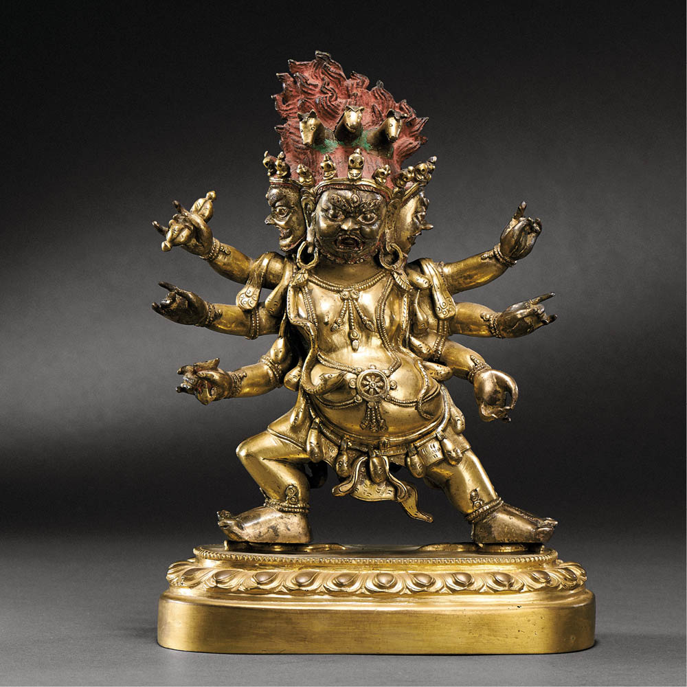 TIBETO-CHINESE, QING DYNASTY (1644-1911) A GILT-BRONZE FIGURE OF THREE FACED WITH SIX-ARMED