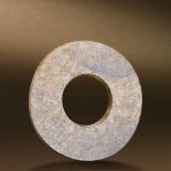 QIJIA CULTURE (CIRCA 2400-1900 BC) AN UNEARTHED WHITE JADE DISC, BI D 10.6 cm. (4 1/4 in.) T 0.5 cm.