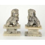 A pair of Chinese carved soapstone dogs of fo 20th century, modelled in seated position upon