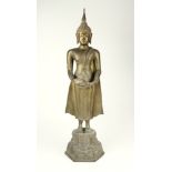 A Thai brass figure of Buddha 20th century, standing and holding an alms bowl, on a decorated