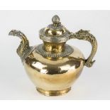 A Tibetan silver and brass teapot 19th century, brass ovoid body on a flared foot, with a makara