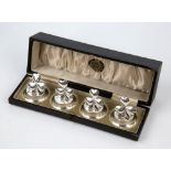 A cased set of four Edwardian silver place card holders, Levi and Salaman, Birmingham 1911, modelled