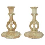 A PAIR OF GRAINGER WORCESTER BLUSH IVORY CANDLESTICKS, 1897 each with foliate nozzle and on three