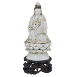 A CHINESE BLANC DE CHINE FIGURE OF GUANYIN, 19TH CENTURY seated on a loose lotus throne base,