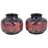 A NEAR PAIR OF MOORCROFT 'POMEGRANATE' SQUAT VASES, CIRCA 1918 tube lined with fruit and foliage