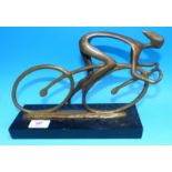 A cast bronze figure of a racing cyclist signed KIM, ebonised base, length 10.5"
