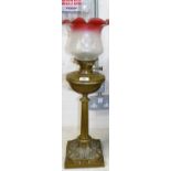 A Victorian brass oil lamp with ruby border shade and chimney (shade a.f.)