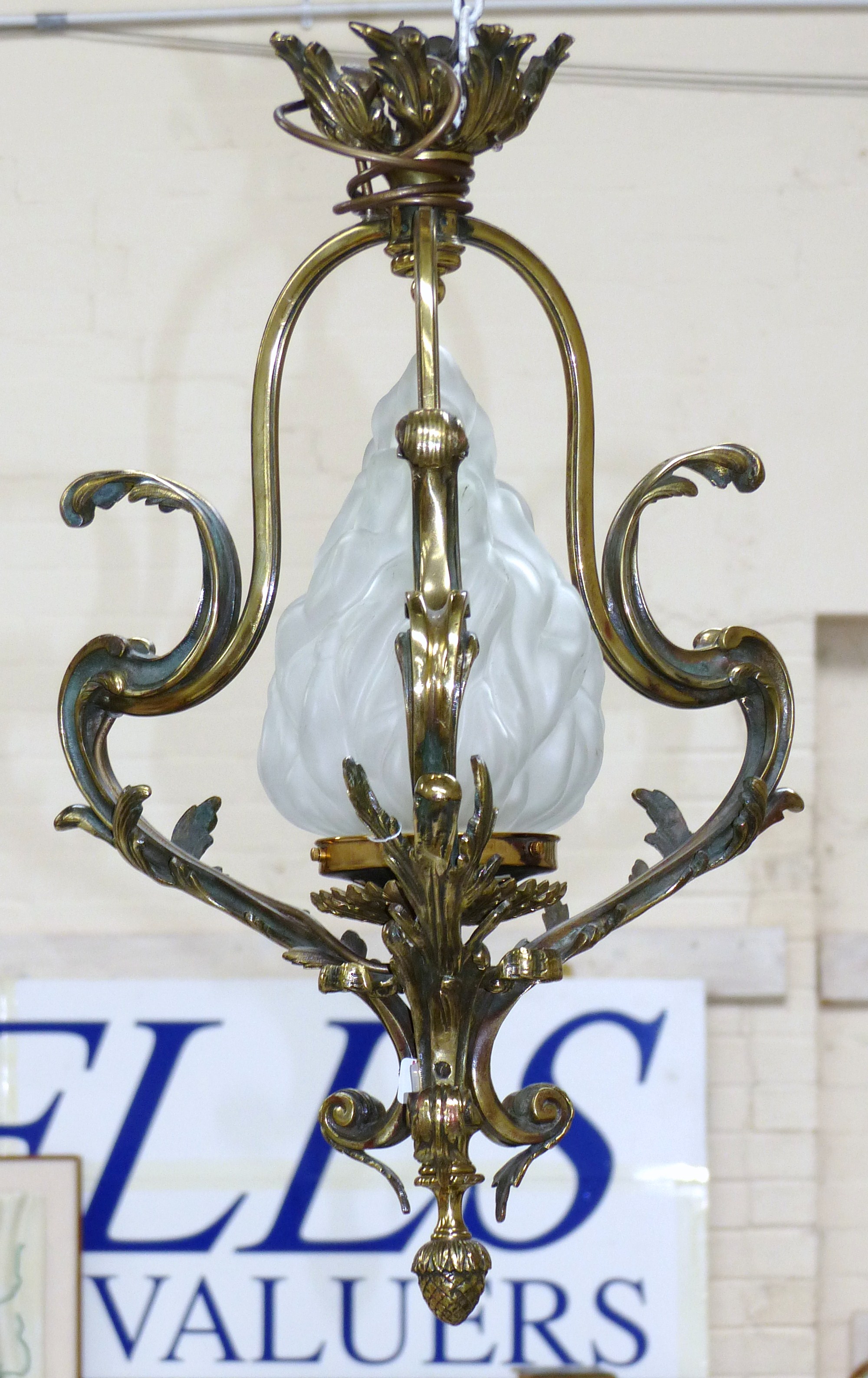 A decorative brass pendant ceiling / hall light with frosted glass flame shaped shade