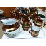 Nine copper lustre jugs and a similar mug