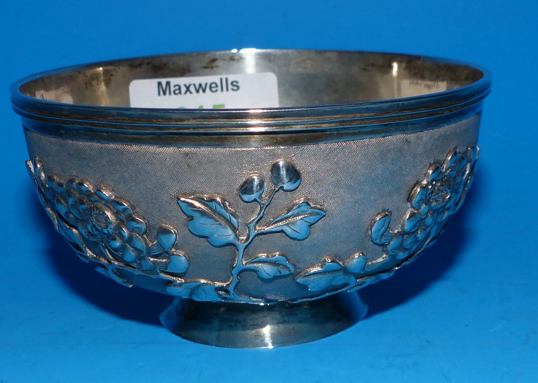 A 19th century Chinese silver bowl with Prunus decoration in relief on stippled ground, 4.3 oz.