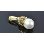 18ct South Sea Pearl PendantA handcrafted scrolled gold and silver cap holdinga 14x17mm white pearl.