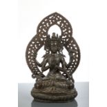 LATE18 / EARLY19TH CENTURY BRONZE DEITY the seated figure on a lotus and with arched backdrop,