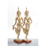 PAIR OF THAI BRASS FIGURES OF FEMALES each of a standing female with one leg kicked out to the back,