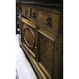 OAK DRESSER with two drawers over three cupboards and with brass handles, 183cm wide