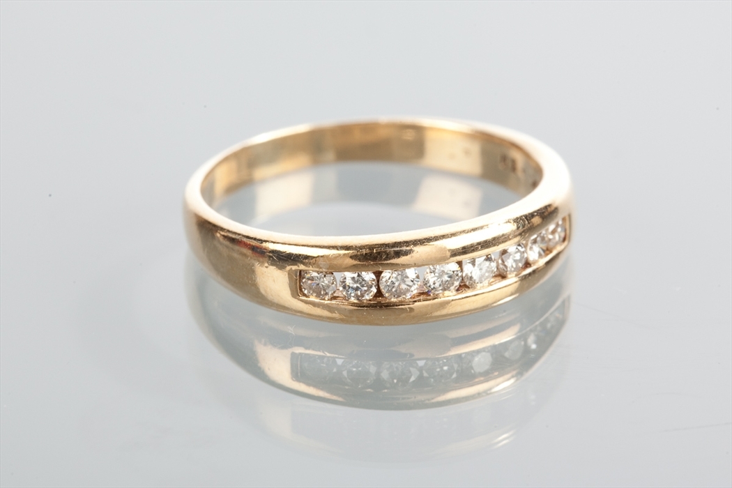 DIAMOND SET BAND with channel set diamonds totalling approximately 0.52 carats, unmarked, size Y-Z