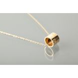 EIGHTEEN CARAT GOLD GUCCI PENDANT ON CHAIN of cylindrical form, with engraved G motifs and dotted