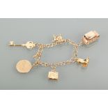 CHARM BRACELET with charms including a car and a book, the bracelet marked 375 for nine carat