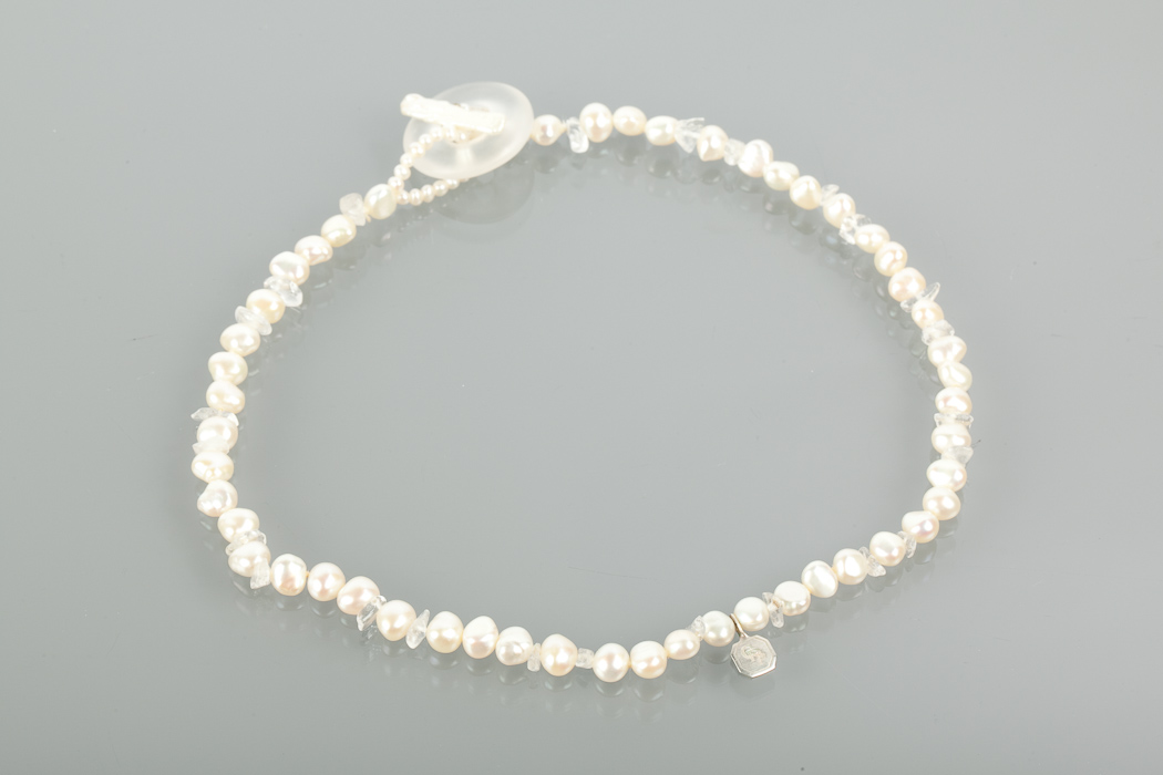 FRESHWATER PEARL NECKLACE formed by two rows of irregular white pearls, with a monogrammed drop