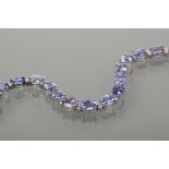 IMPRESSIVE TANZANITE AND DIAMOND TENNIS BRACELET 
set with a total of 18 carats of oval brilliant