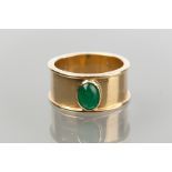 EMERALD RING
set with a central oval cabochon emerald, on a wide band, in eighteen carat gold, 9.