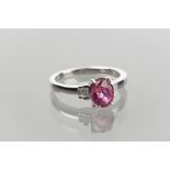 EIGHTEEN CARAT WHITE GOLD PINK SAPPHIRE AND DIAMOND ACCENT RING 
set with a central oval pink