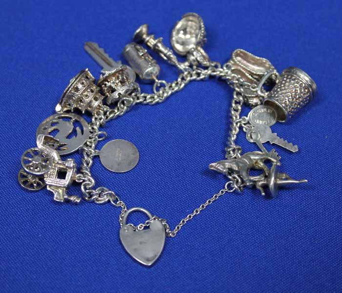 GOOD SILVER CHARM BRACELET
with charms including a caroussel, a post box, a horse etc.