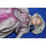 EARLY 20TH CENTURY BISQUE HEAD DOLL
wearing a purple dress, with articulated composition body,