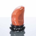 SCHOLAR'S GLASS ROCK
in polished russet coloured stone, resting on a pierced wooden stand,