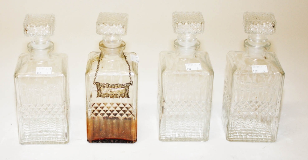 A SET OF FOUR SQUARE MOULDED GLASS CASE DECANTERS, each with conforming stopper, 9in (23cm). (4)