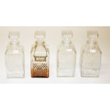 A SET OF FOUR SQUARE MOULDED GLASS CASE DECANTERS, each with conforming stopper, 9in (23cm). (4)