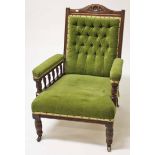 AN EDWARDIAN WALNUT ARMCHAIR, with button back, on front turned legs, covered in green draylon. (1)