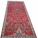 A SHORT IRON RED GROUND PERSIAN RUNNER,