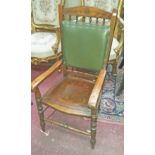 AN EDWARDIAN OAK ARMCHAIR, with padded back above a solid seat, on turned legs. (1)