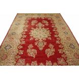 A LARGE DARK RED GROUND WOOL CARPET, with star shaped centre floral medallion and floral sprays,